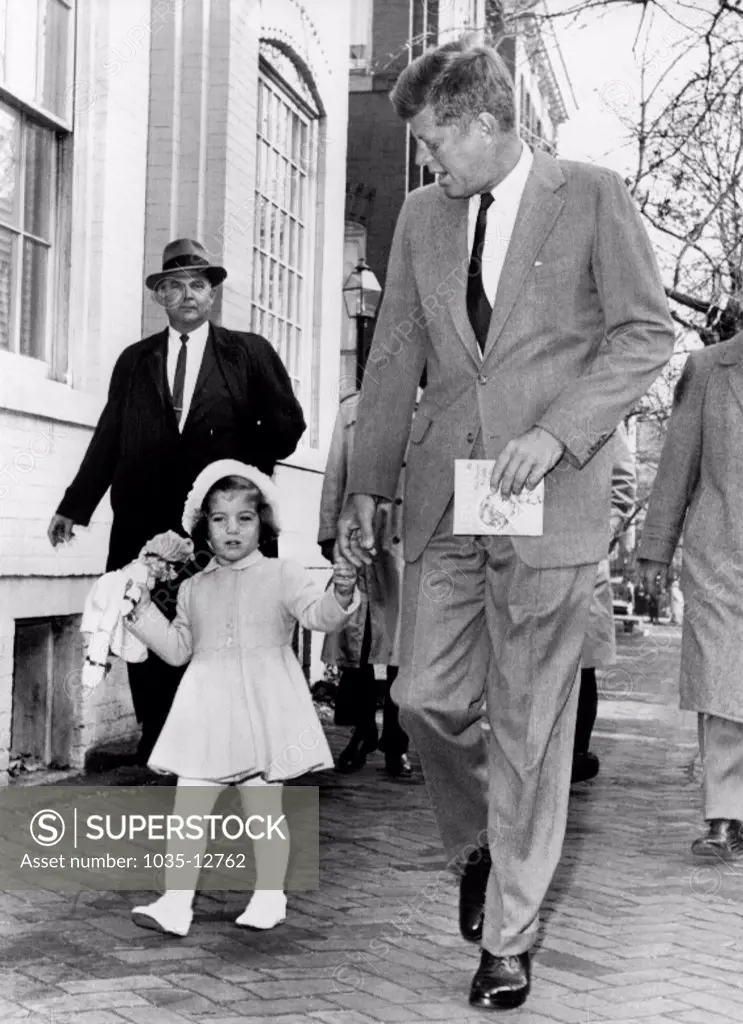 Washington, D.C.:  November 27, 1960 President-elect Kennedy walks with his daughter Caroline on their way to church services on her third birthday. Afterwards Kennedy went to Georgetown Hospital to visit his wife and their new-born son.