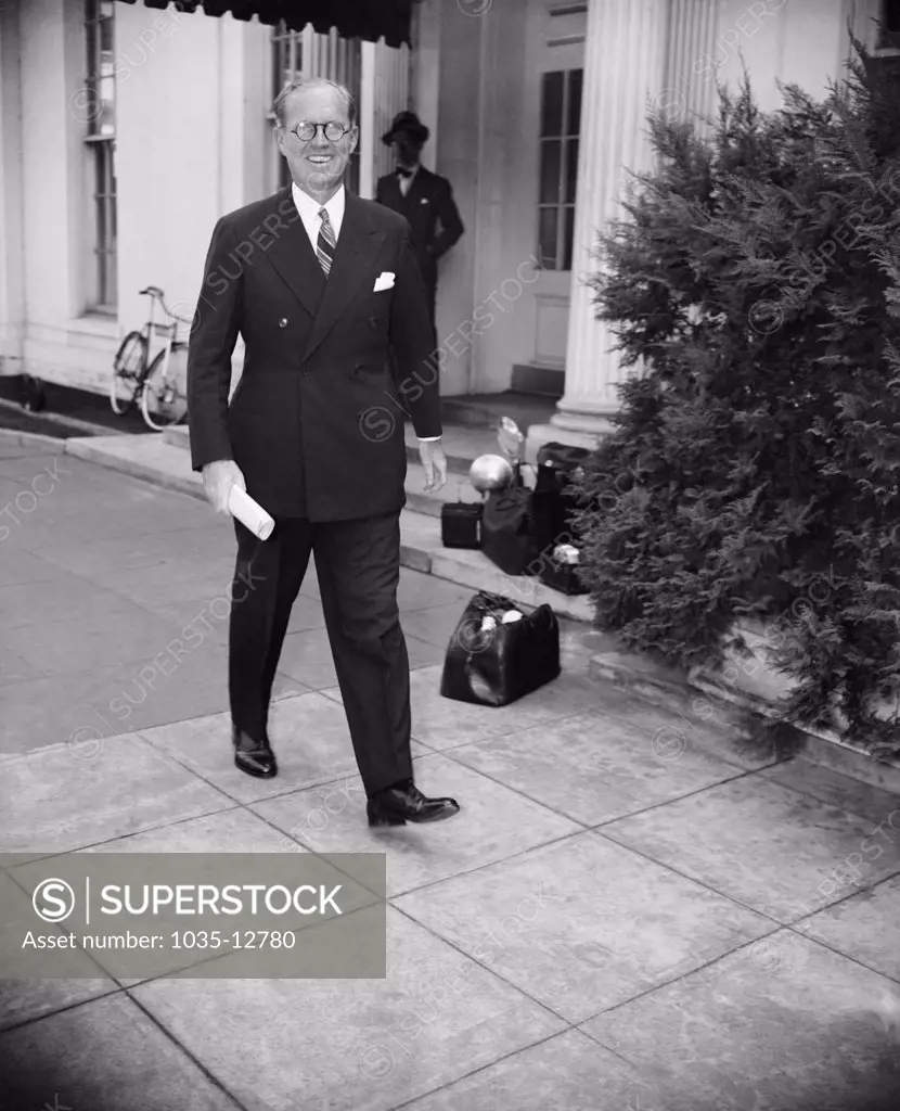 Washington, D.C.:   September 14, 1937 Following a conference at the White House today between President Roosevelt and Joseph P. Kennedy, Chairman of the Maritime Commission, the Chief Executive issued an order forbidding Government-owned merchant vessels to transport arms or ammunition to Japan or China. Kennedy is shown leaving the conference.