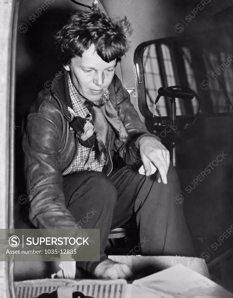 Oakland, California:  March 14, 1937 Aviatrix Amelia Earhart checks her cockpit supplies for her departure to Honolulu on the first leg of her globe circling flight.