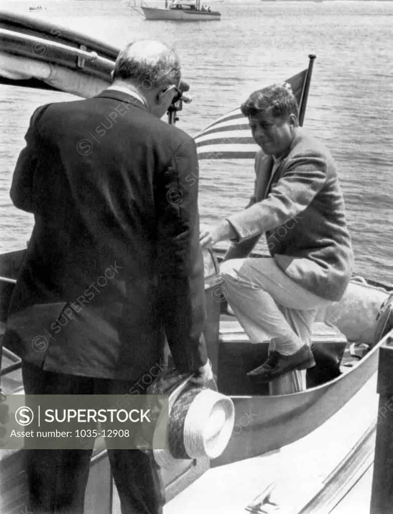 Hyannis Port, Massachusetts:  July 8, 1961 President Kennedy steps into the cockpit of the yacht, 'Marlin', as Secretary of State Dean Rusk walks aft.