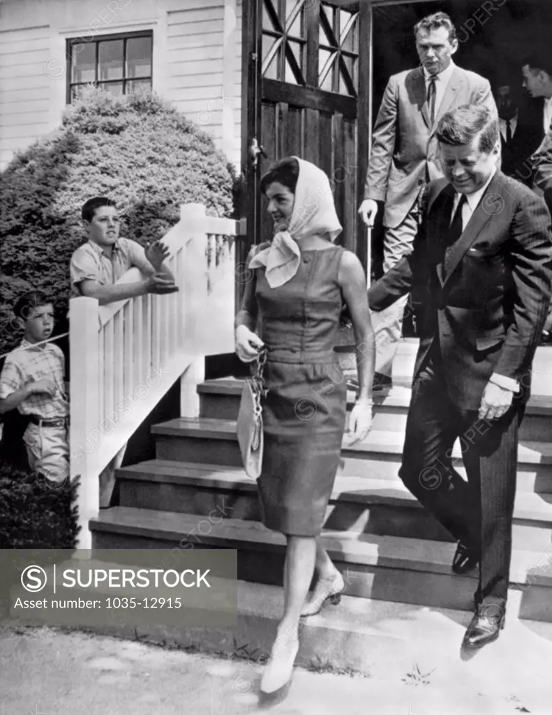 Hyannis, Massachusetts:  July 2, 1961. President Kennedy and Jackie leaving the St. Francis Xavier church after attending mass. Jacqueline is wearing a green linen sheath dress and a white kerchief.