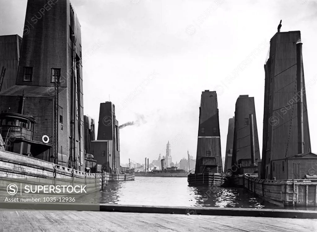 New York, New York:  c. 1925 Floating grain elevators in New York City harbor.