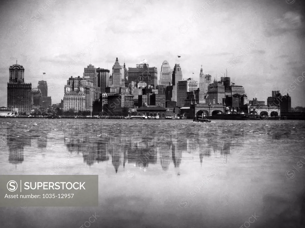 New York, New York:  c. 1925 The New York Battery skyline reflected in the harbor waters.