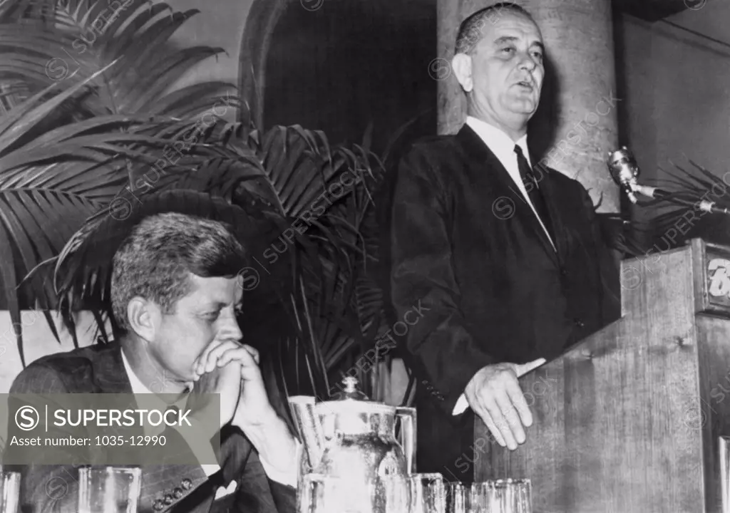 Los Angeles, California:  July 15, 1960 Democratic Presidential nominee Sen. John Kennedy listens as his running mate, Sen. Lyndon Johnson, assures a group of Negro delegates to the National Convention that the party's new ultra-liberal platform has his whole-hearted support.