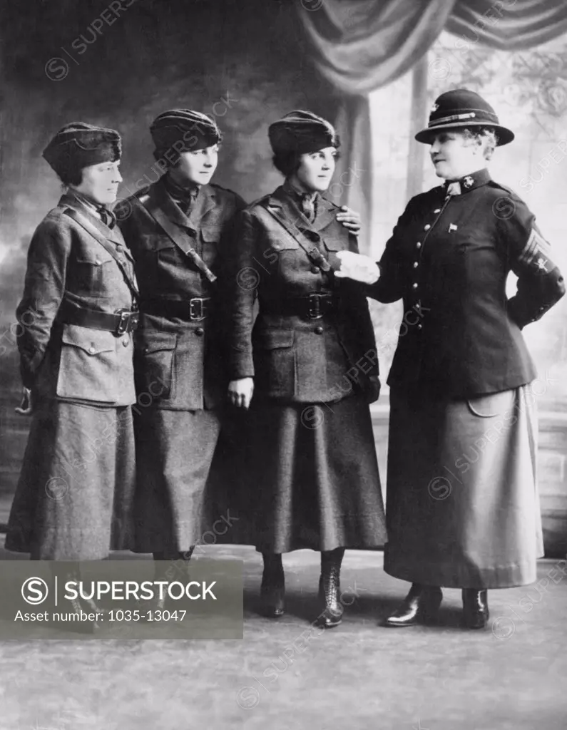 United States:  c. 1918 Actress and singer Lillian Russell is a Sargeant of the First Marine Corps Women's Reserve and is giving instructions to three new privates first class.