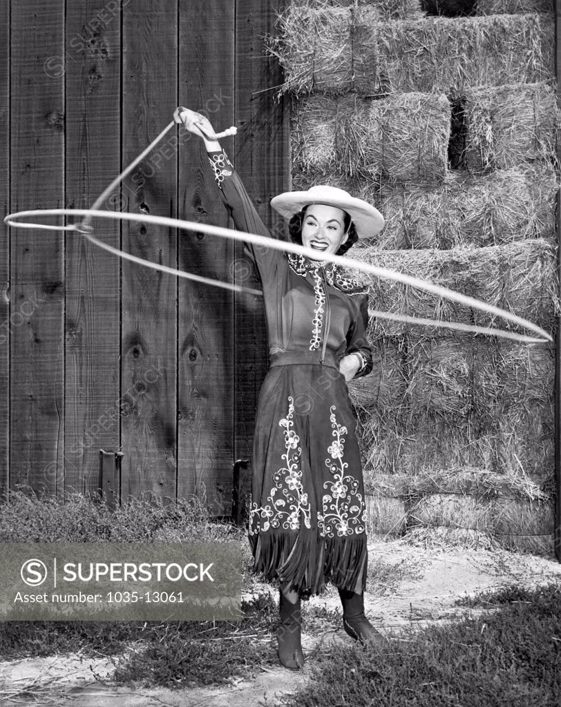 Hollywood, California:  c. 1954 Actress Ann Blyth shows off her cowgirl rope spinning skills.