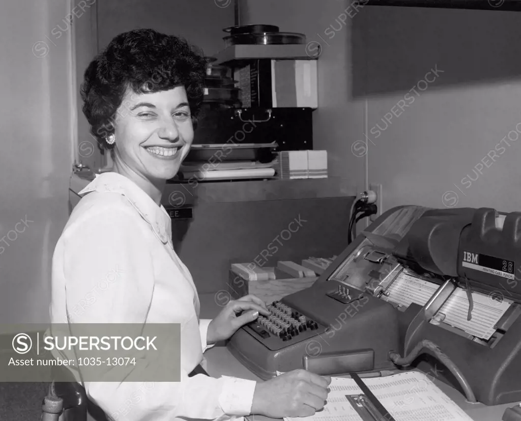 United States:  c. 1951 A woman in an office entering data into an IBM 26 Printing Card Punch machine.