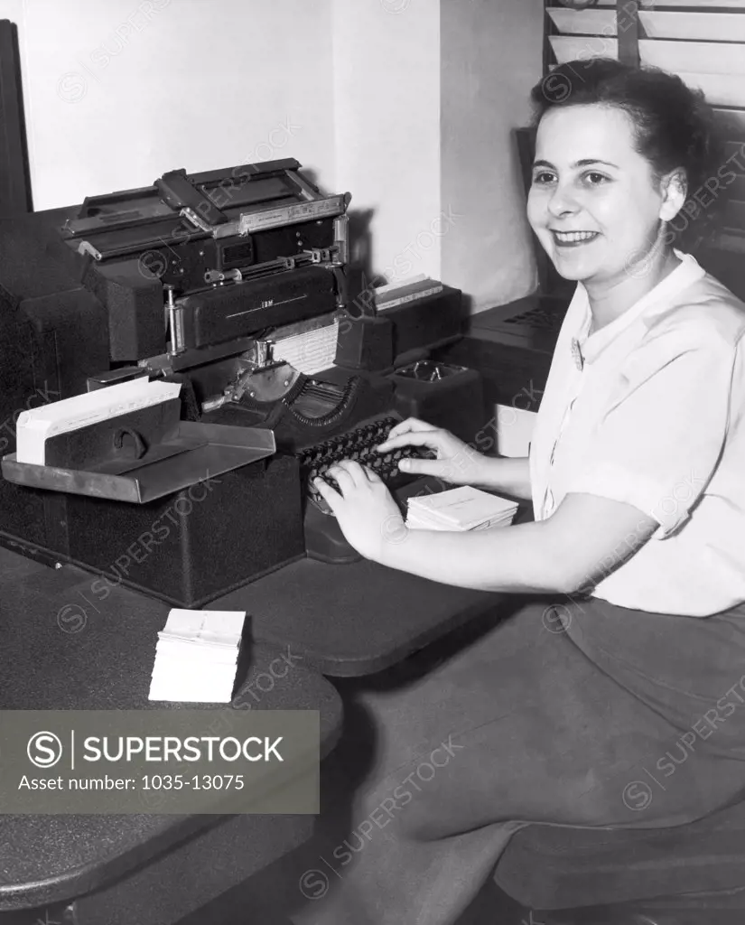 Cleveland, Ohio:  February, 1951 A woman office worker entering data into an IBM punch card machine at the Erie Railroad Company offices.