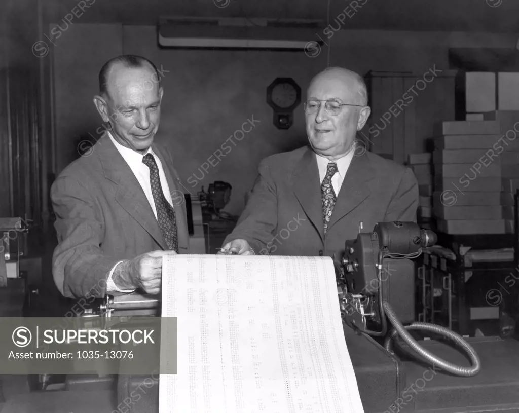 Cleveland, Ohio:  1951 Executives viewing printed out data sheets at the Erie Railroad offices.