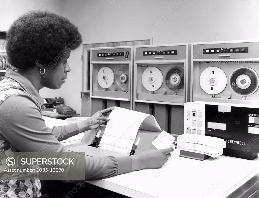 United States:  c. 1969 A woman working on a Honeywell tape drive computer.