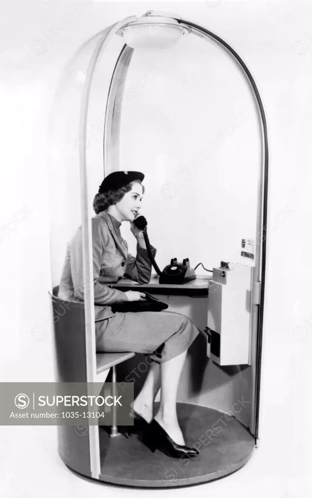 United States: 1958 A woman inside what the phone booth of the future looked like in 1958.