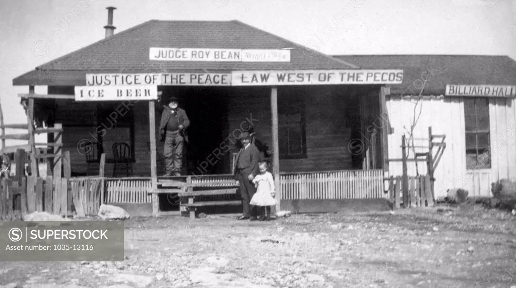 Langtry, Texas:  c. 1890 Judge Roy Bean standing on the porch of his courtroom, notary office, saloon and billiard hall.