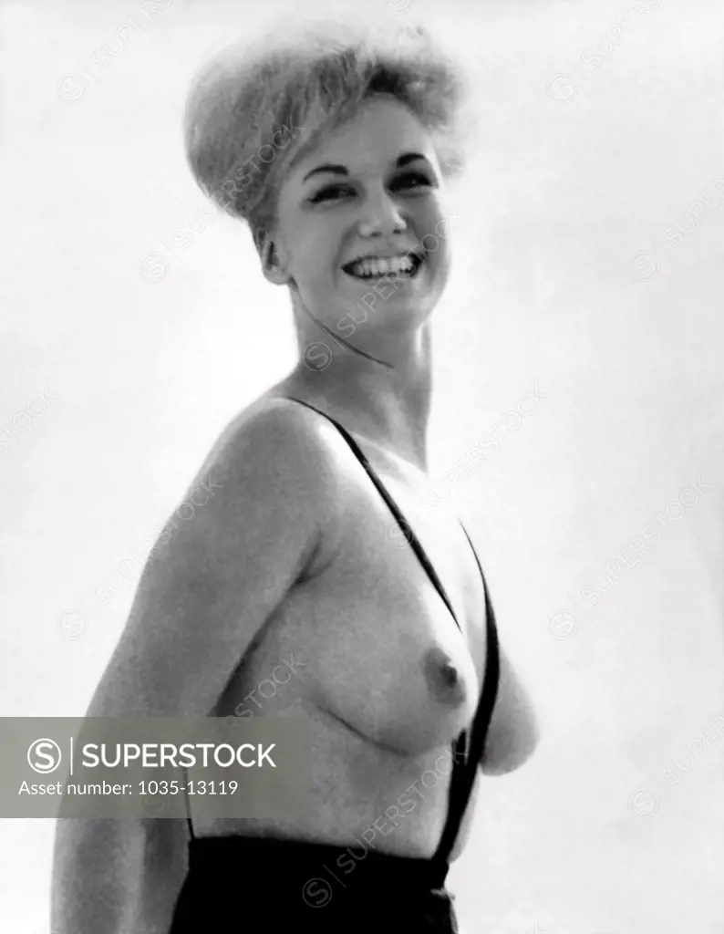 United States:  1964 A young woman models Rudy Gernreich's topless bathing suit, the 'monokini'.