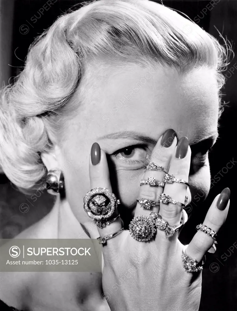 New York, New York:  August 11, 1952 Model Pat Burrage wears a entire collection of rose design engagement rings at the American National Retail Jewelers annual convention. They're worth around $50,000.
