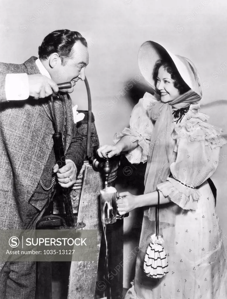 Los Angeles, California:  April 11, 1933 The first Hollywood motion picture set in fourteen years to use real beer has Sylvia Sidney tapping a stein of beer for Edward Arnold as he pumps.