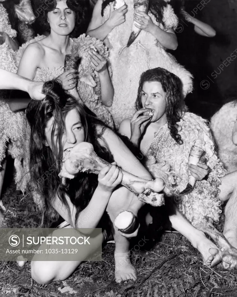 Chislehurst, Kent, England:  September 29, 1954 British members of the Speleological Society hold an 'Ancient Briton' dinner party in a cave here. The cave men and women, dressed in sheepskins, drank from horn cups and ate fungi, nuts, wild fruit and meat.