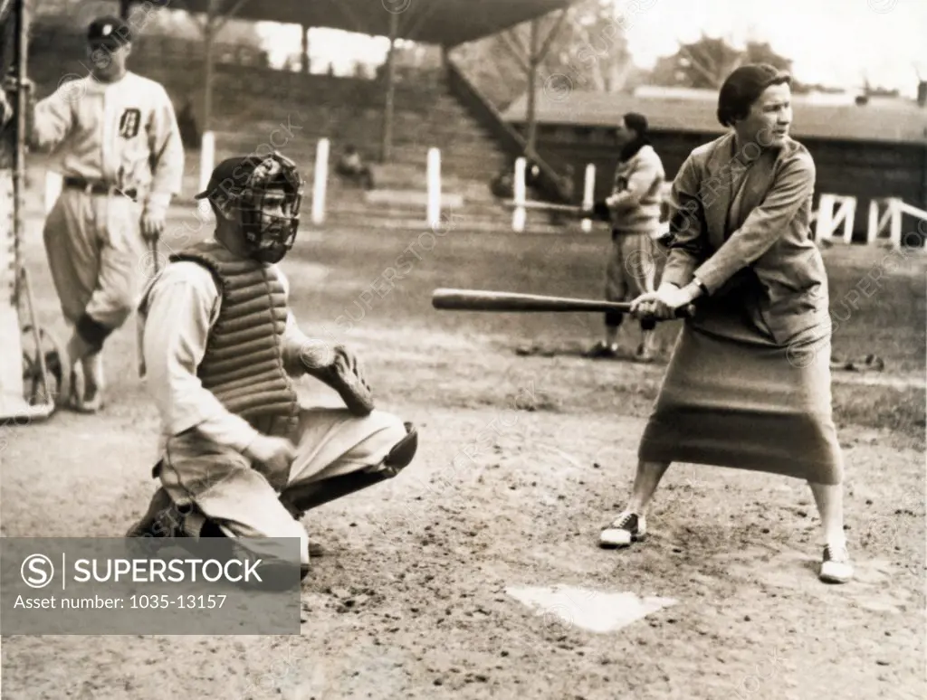 Augusta, Georgia:  April 6, 1926 Tennis star Elizabeth Ryan tests her batting eye out at the Detroit Tigers spring training camp. Ty Cobb is an interested spectator in back.