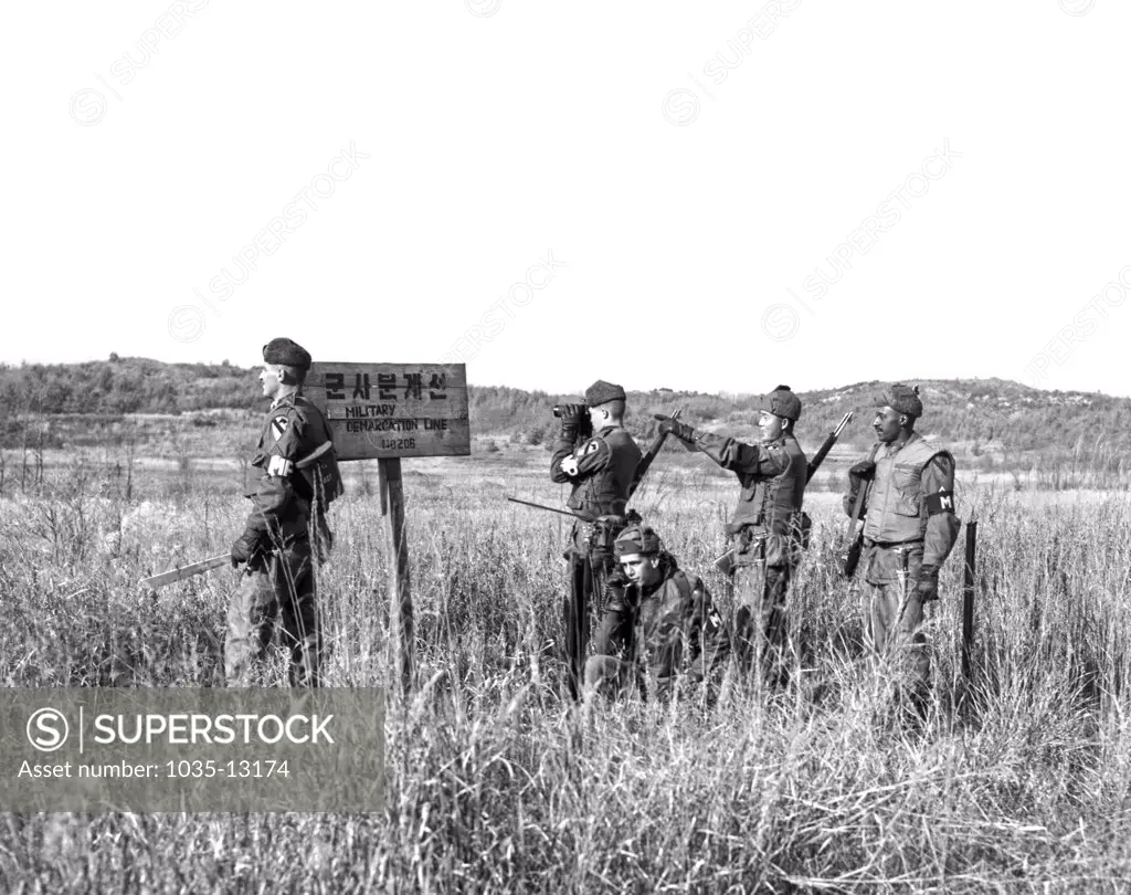 Korea: December 6, 1962 Members of a U.S. Army patrol pause at the Military Demarcation Line for a look into North Korea.