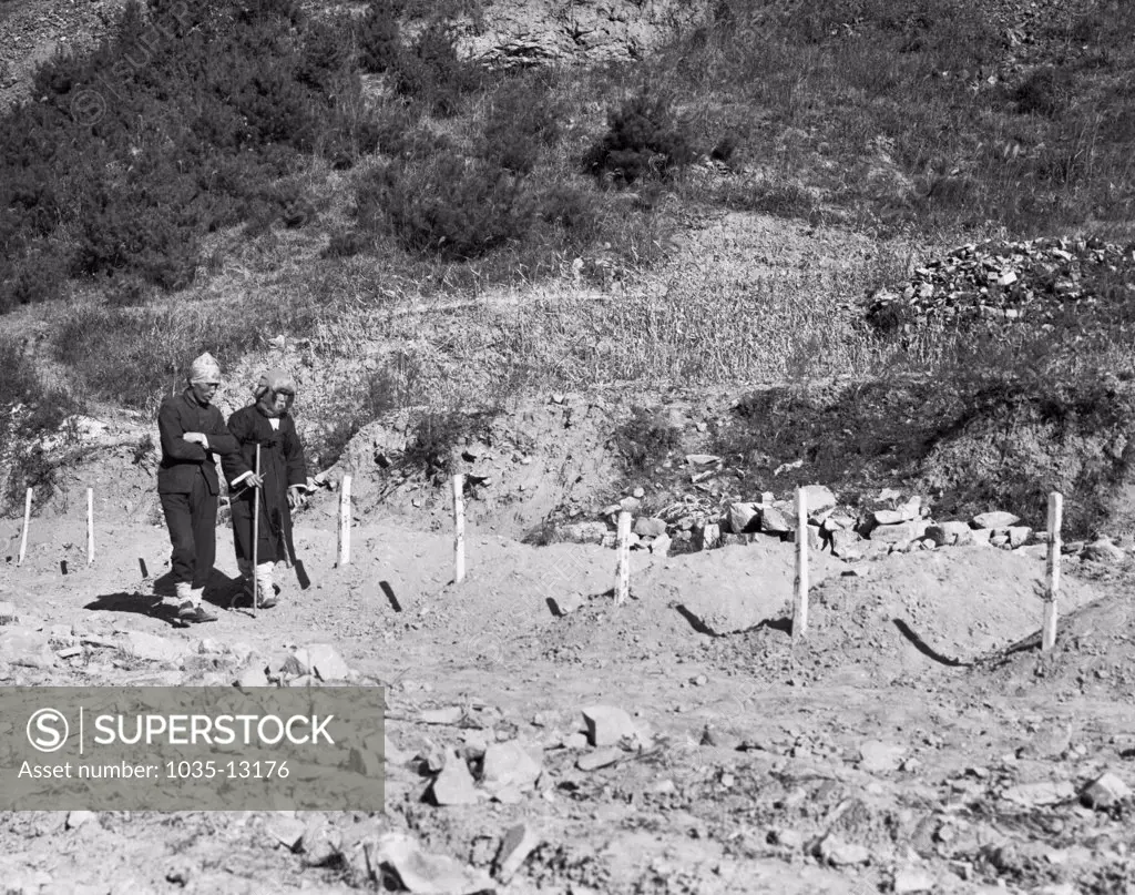 Korea:  December 13, 1950 A North Korean couple look for their son's grave at Duk San Nichel Mine where North Korean communists killed over 1000 anti-communists during their retreat.