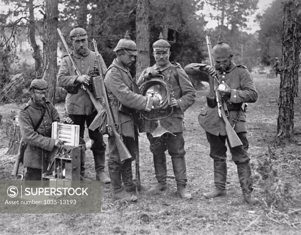 Germany:  c. 1916 German soldiers with one of their country's latest inventions, a portable searchlight  for night work in the trenches and on the battlefield. When not in use, it is taken apart and its parts are distributed among five men. When needed it is quickly assembled and put into use.