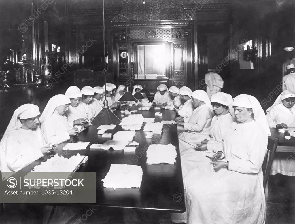 New York, New York:   c. 1917 Members of a Red Cross auxiliary chapter make surgical dressings for the war in the home of John D. Rockefeller on 54th Street in New York.