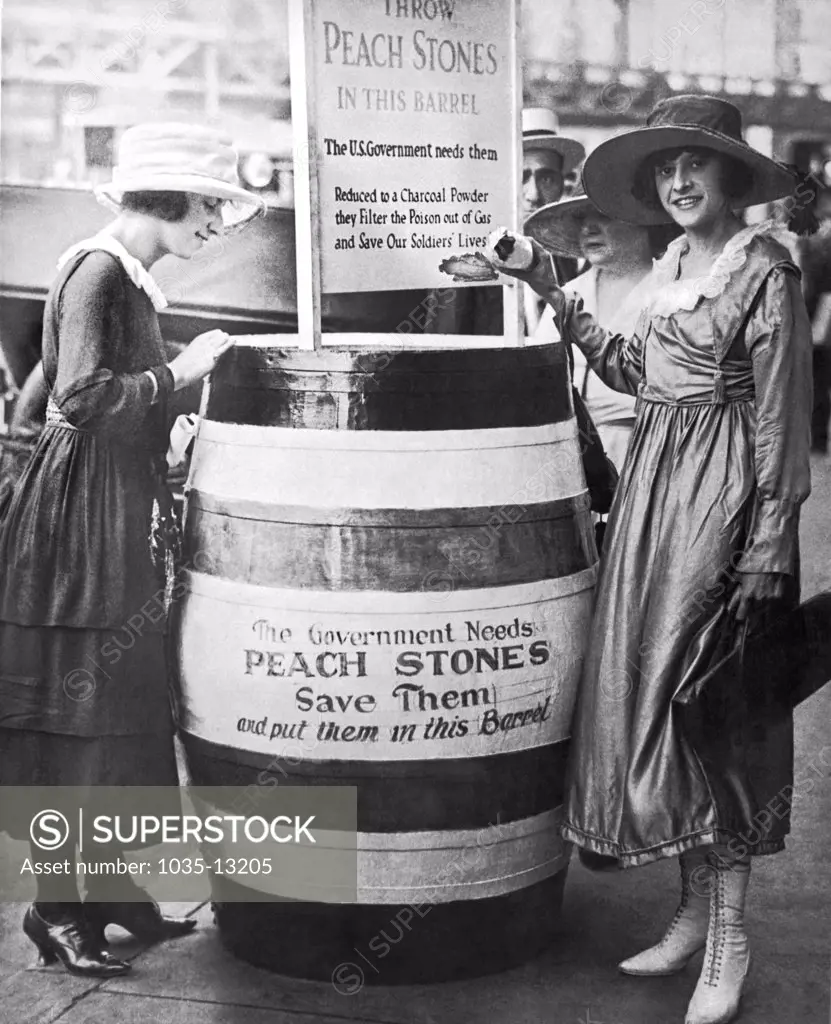 New York, New York:  August 24, 1918   Two young women oontribute to the drive to gather peach pits which are ground up to a charcoal powder and used to filter the poison out of gas warfare.