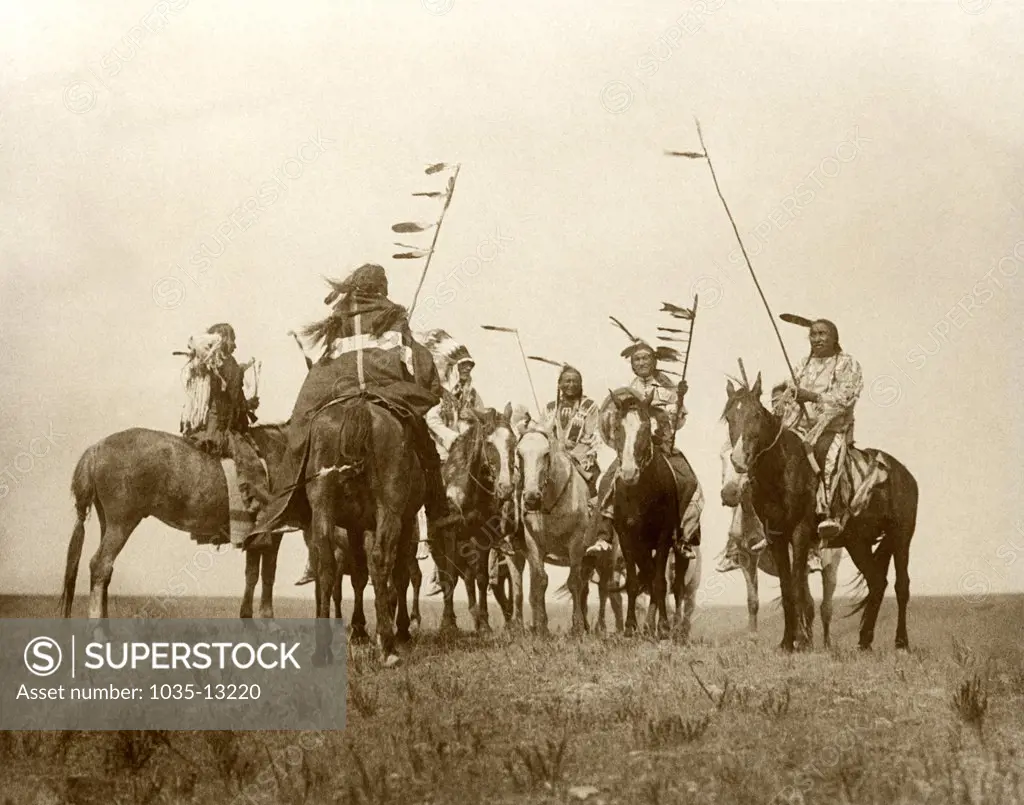 Montana:  1908. An Edward S. Curtis photogravure of Atsina warriors on horseback.