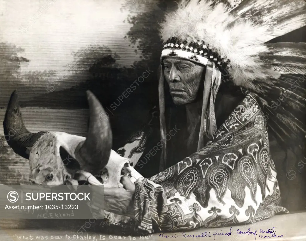 Montana:  1928  Photograph of Cree Chief Mo-See-Ma-Ma-Mos, Young Boy, holding a buffalo skull. He was western artist Charlie Russell's good friend and favorite model.