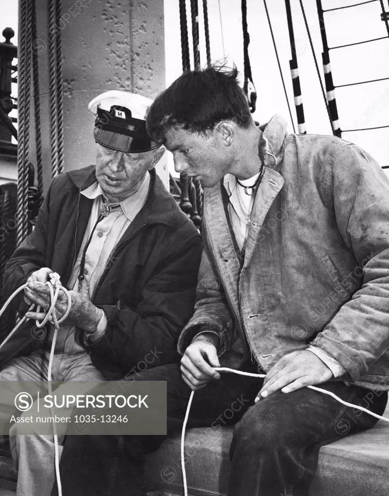 San Francisco, California:  c. 1962 An old sailor gives a young man lessons in tying knots.