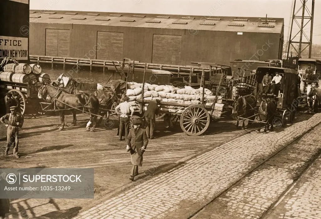 New York, New York:   c. 1915 Wagons in line to load the first of John D. Rockefeller's food ships for Belgium.