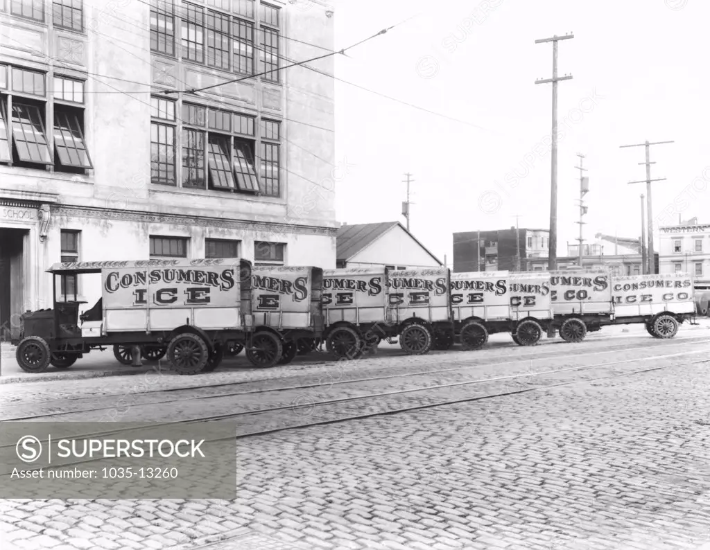 San Francisco, California:  c. 1915 Eight Consumers Ice Company trucks parked in front of a school.