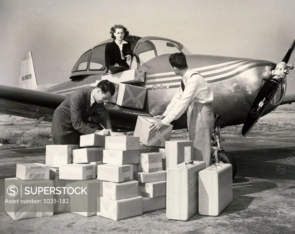 Mid adult man loading cargo into an airplane