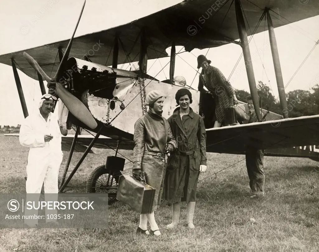 Passengers stepping out of a biplane