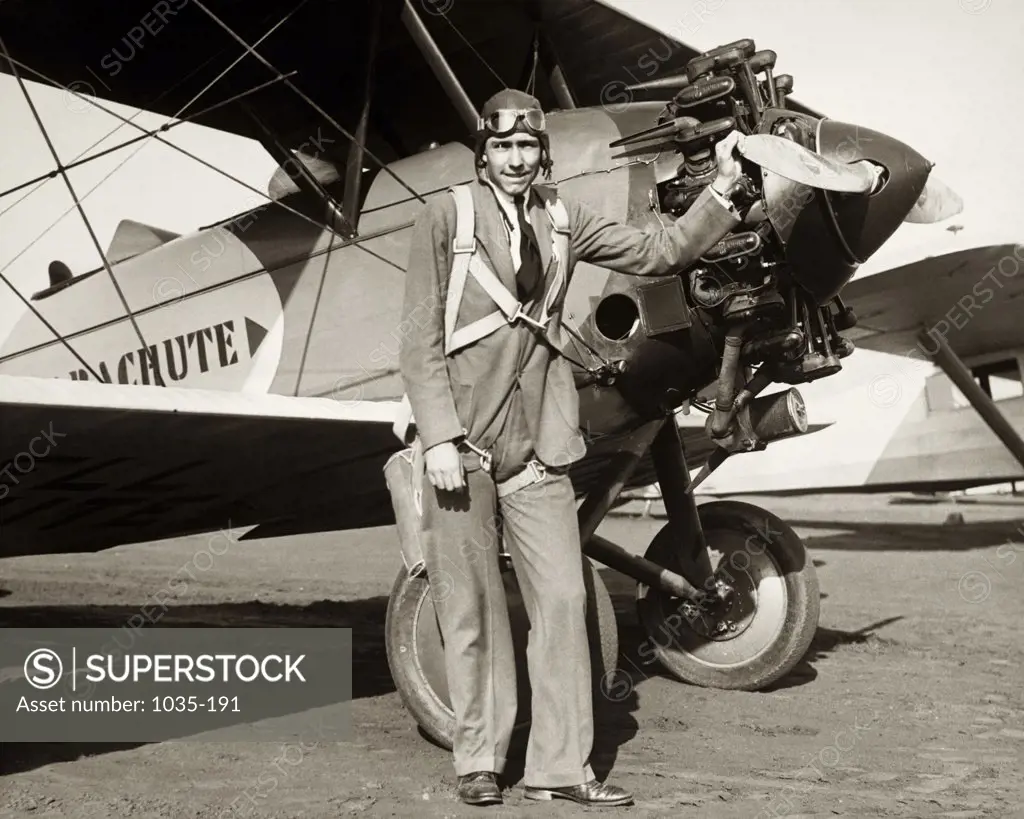 Portrait of a mid adult man standing near a biplane