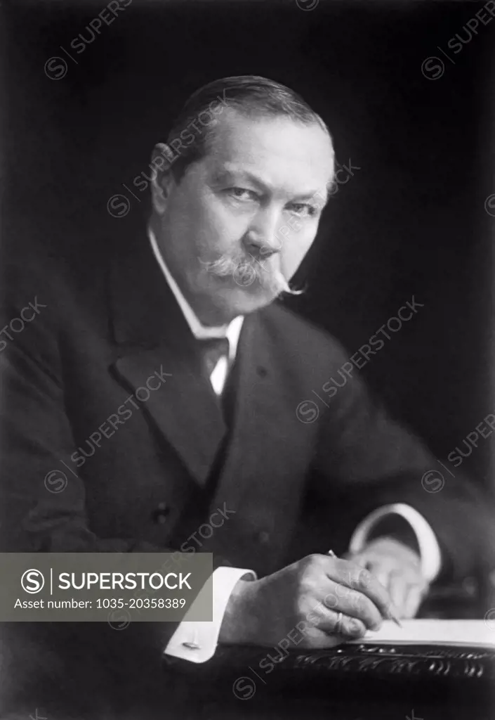 England:  1923 Author Sir Arthur Conan Doyle of the noted Sherlock Holmes series writing at his desk.
