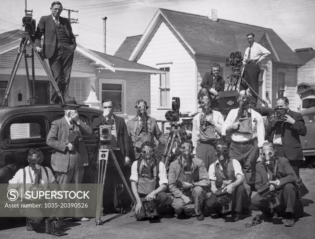 Salinas, California:  September 17, 1936. News reporters and cameramen covering the Salinas lettuce workers' strike have equipped themselvers with gas masks after suffering the affects of tear gas  on previous days.