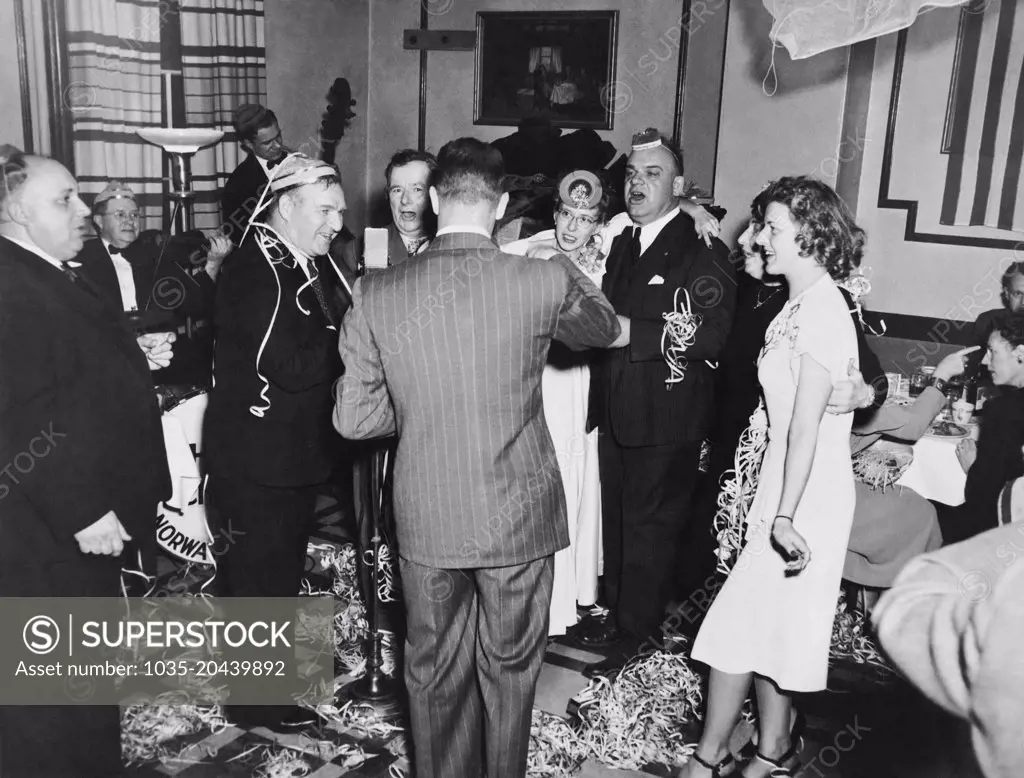 United States:   January 1, 1948 A group of people at a New Year's Eve party at the Hotel Stone singing and having much fun.