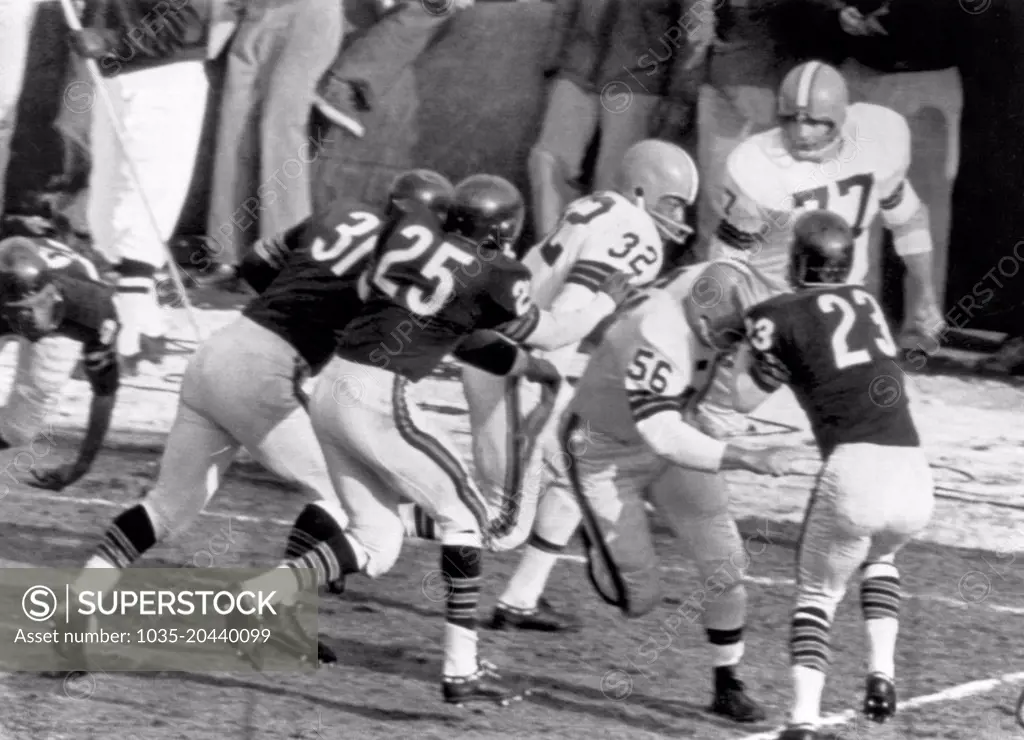 Chicago, Illinois:  December 10, 1961 The Cleveland Browns' John Morrow (56) makes a block on the Chicago Bears'  Dave Whitsell (23) and the Brown's running star Jim Brown (32) is off for a 90 yard run and a touchdown