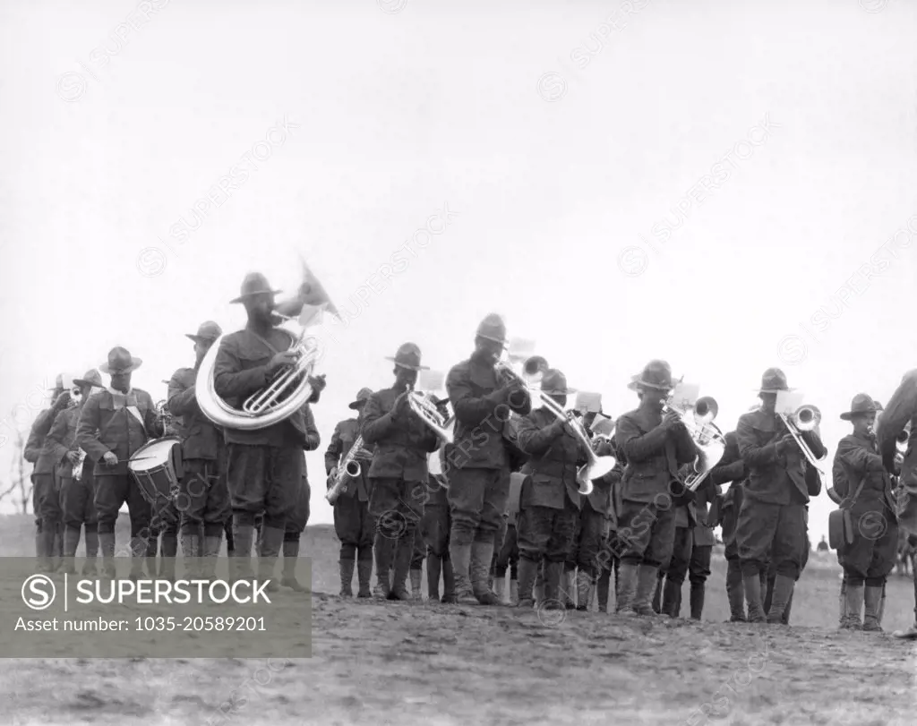 World:  c. 1918. Members of the 369th Infantry Regiment band under the direction of Lt. James Reese Europe. The 369th was also known as the "Harlem Hellfighters", and was previously the New York 15th Regiment.