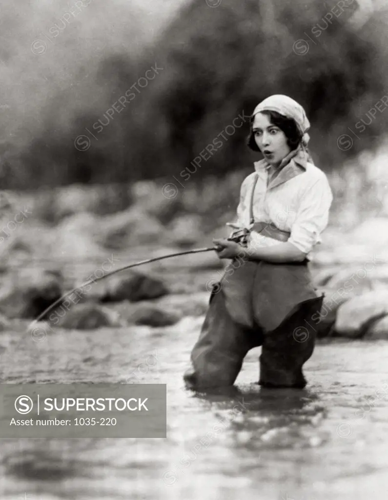 Young woman fishing in a stream