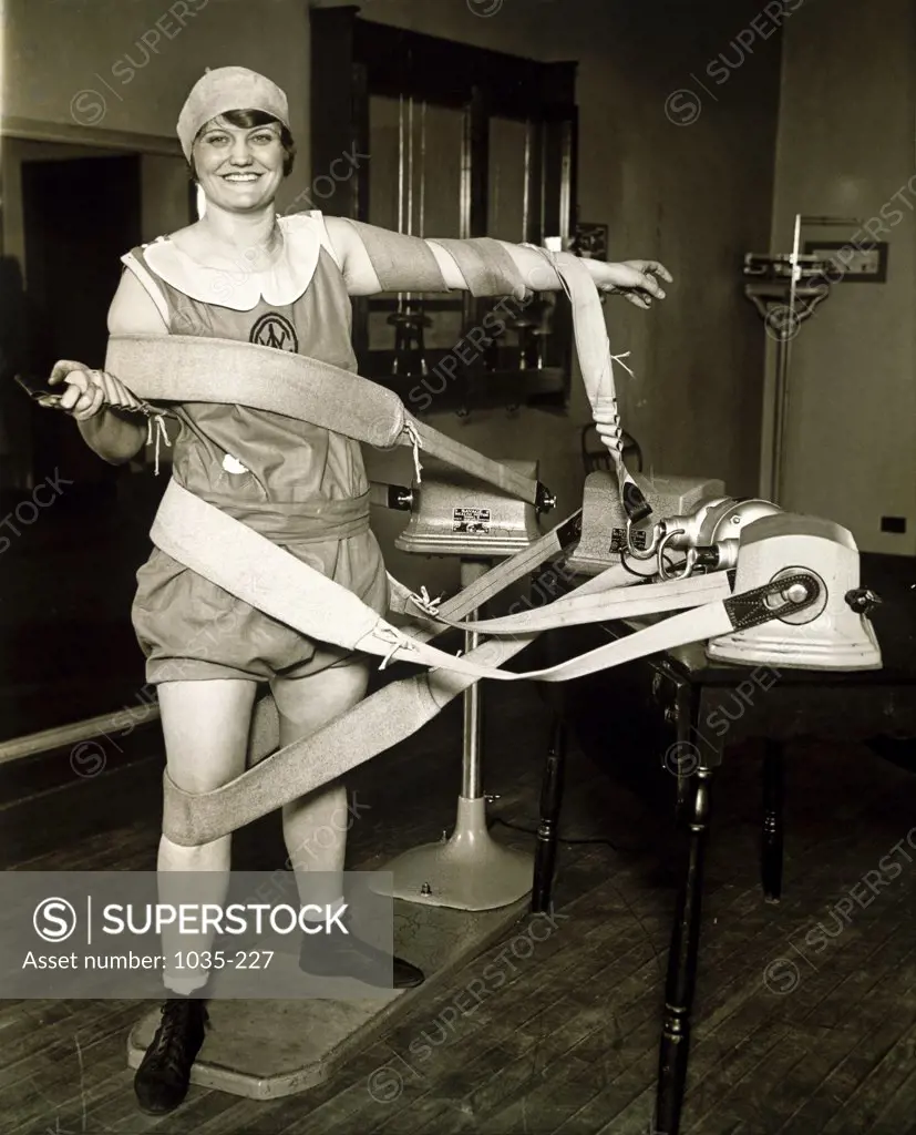 Portrait of a mid adult woman exercising on an electric vibrating machine