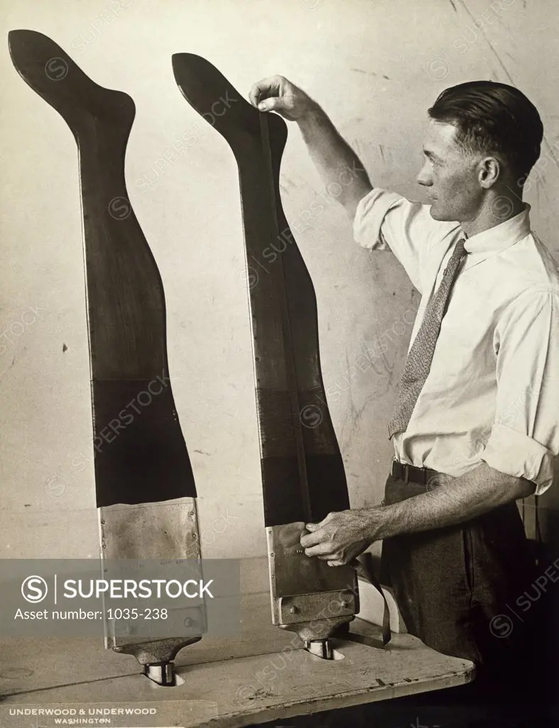 Side profile of a mid adult man measuring the length of stockings, United States Bureau of Standards, 1931