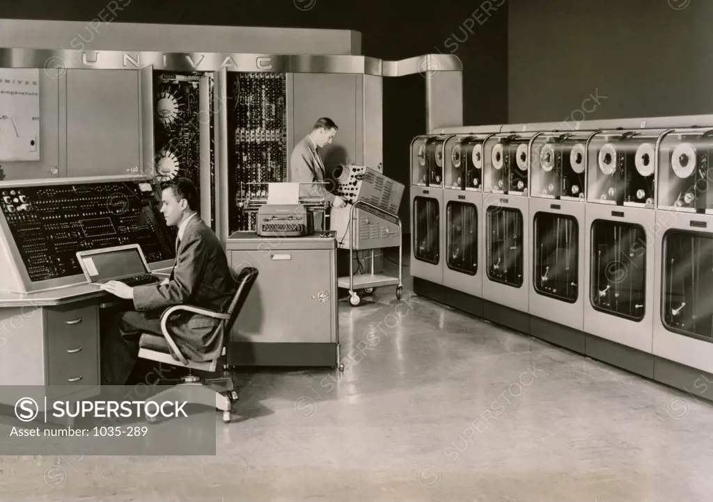 Two businessmen working on computers in an office, Remington Rand UNIVAC Computer, 1951