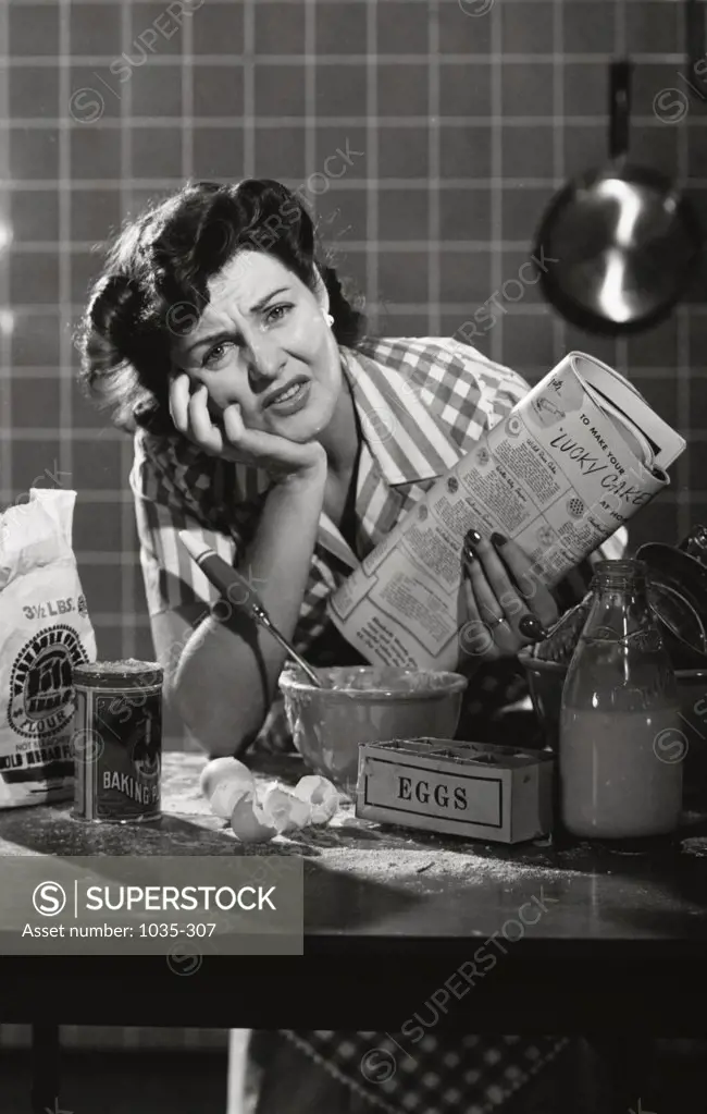Portrait of a mid adult woman sitting in the kitchen looking frustrated