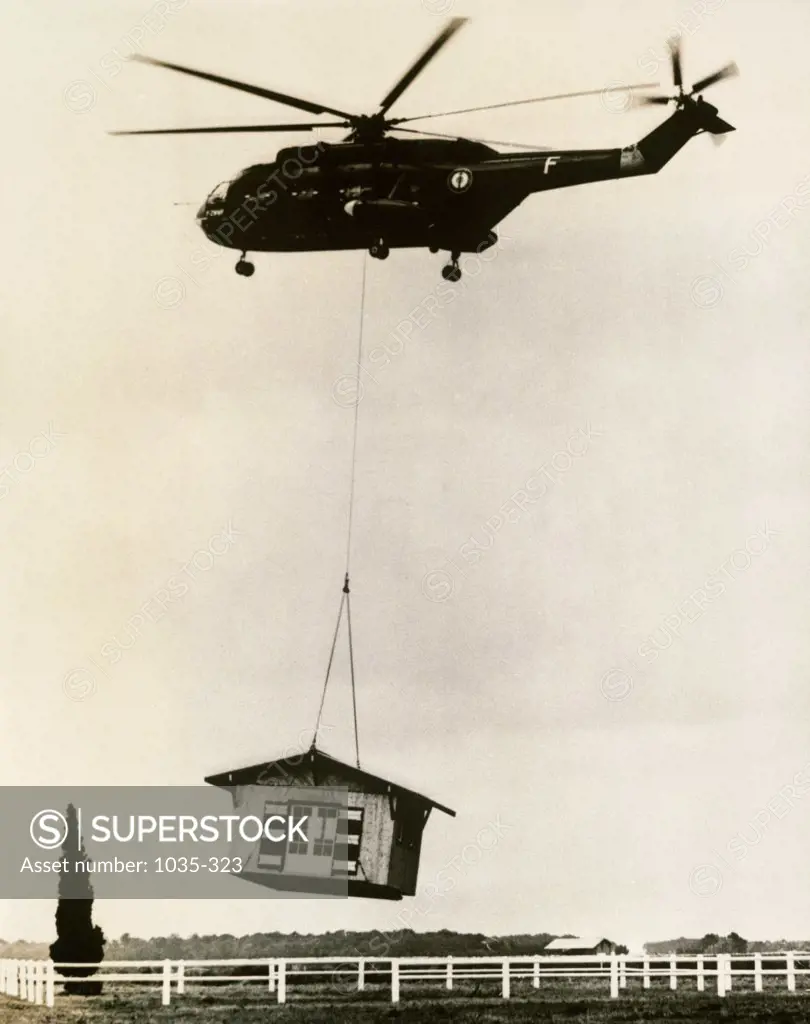 Low angle view of a helicopter lifting a house