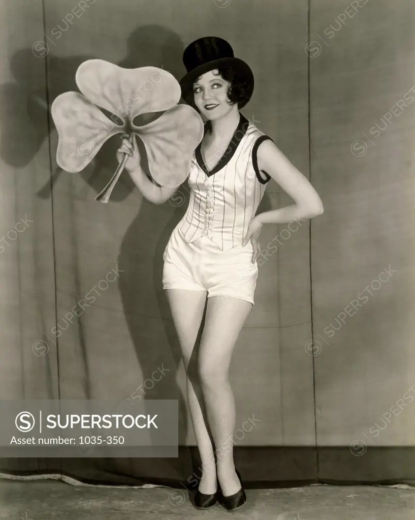 Young woman standing on a stage holding a clover