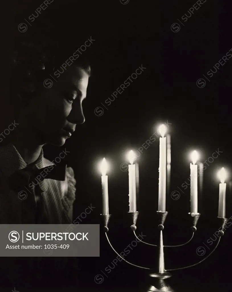 Close-up of a young woman looking at a candlestick holder