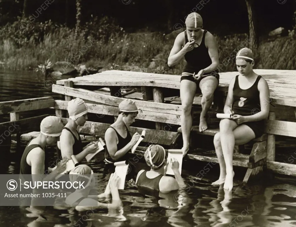 Group of young women writing on note pads during swimming, Camp Kitteredge, New York, USA, 1926