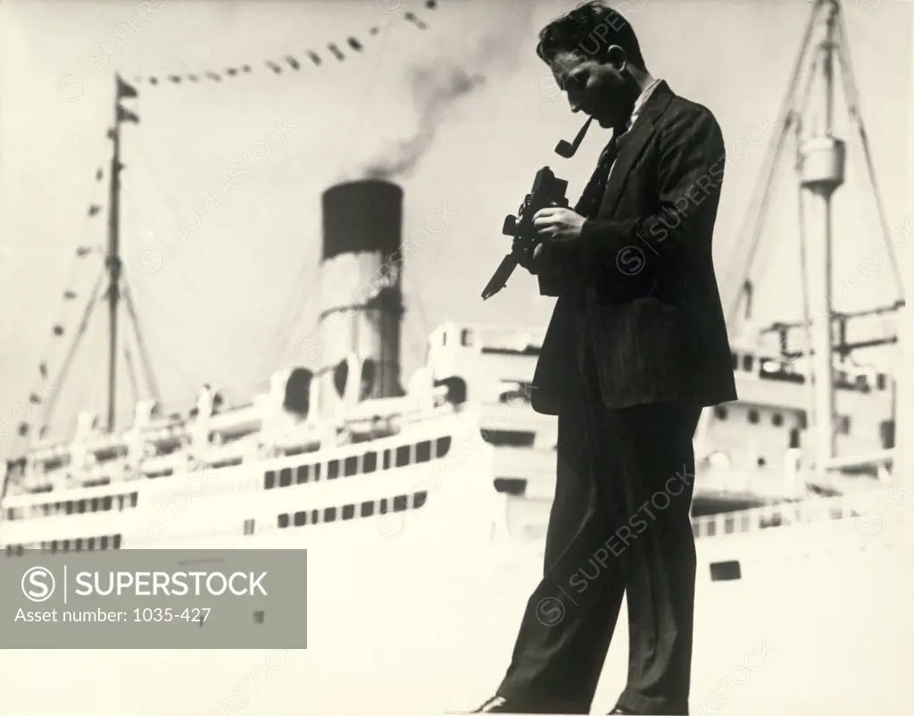 Side profile of a mature man holding a camera in front of a cruise ship