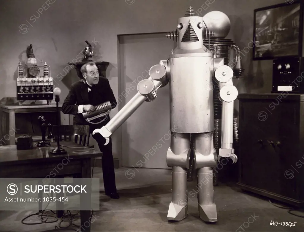 Senior man standing near a robot